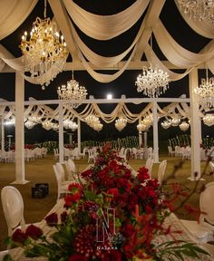 an outdoor wedding venue with chandeliers and flowers