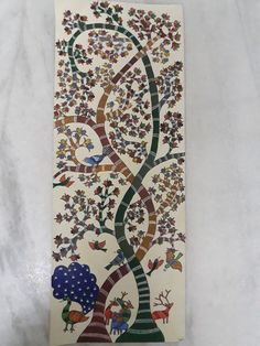 an artisticly designed ceramic tile depicting a tree with colorful leaves and animals on it