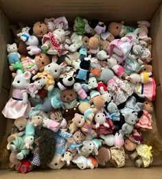 a cardboard box filled with lots of stuffed animals in different colors and sizes on top of each other