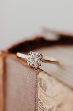 an engagement ring sitting on top of a book