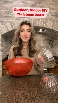 a woman sitting at a counter with a red object in front of her and the words outdoor / indoor diy christmas decor