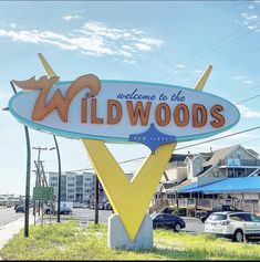 the welcome sign for wildwoods is in front of some cars parked on the side of the road