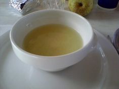 a bowl of soup sitting on top of a white plate