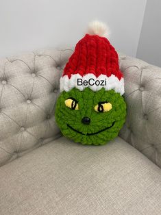 a crocheted beanie hat sitting on top of a couch next to a stuffed animal