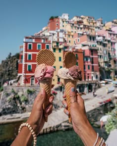 two people holding ice cream cones in their hands