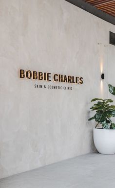 the entrance to bobbie charles skin and cosmetic clinic, with plants in front of it