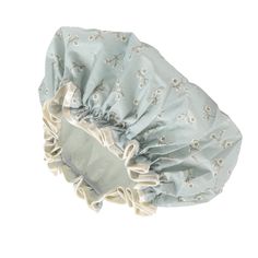 a blue and white flowered bonnet with ruffles on the top, sitting in front of a white background