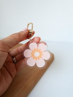 a person holding a flower shaped key chain