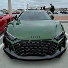 a green car parked in a parking lot next to other cars