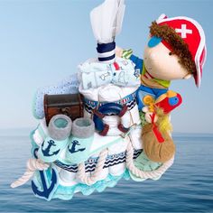 a stuffed animal is hanging from the side of a boat in the ocean with other items on it