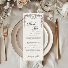 a table setting with place cards and silverware