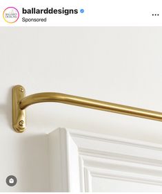 a close up of a gold handle on a white door