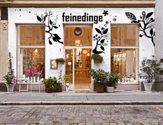 a white building with potted plants in front of it and the words ferndings written on the side