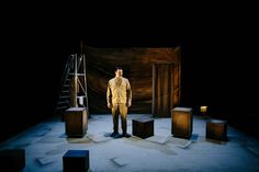 a man standing on top of a stage surrounded by blocks and boxes in front of him