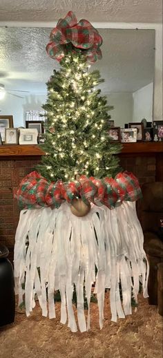 a christmas tree decorated with red, white and green ribbon