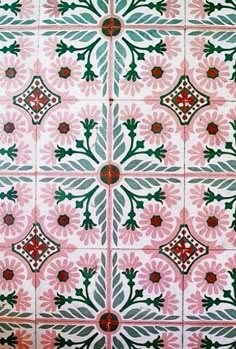 a pink and green tile pattern with red accents on the bottom half of the tiles