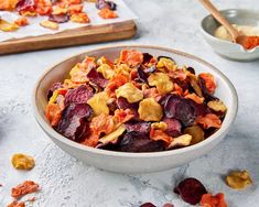 a bowl filled with beets and nuts next to two bowls full of dried fruit