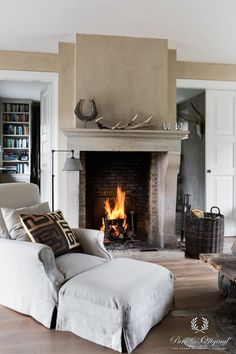 a living room filled with furniture and a fire place in the middle of the room