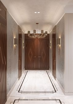 an elegant hallway with two doors and chandelier