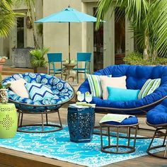 an outdoor patio with blue furniture and palm trees in the backgroung area