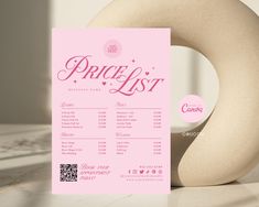 a pink price list sitting on top of a table next to a large white object