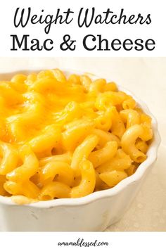 a white bowl filled with macaroni and cheese on top of a table next to a