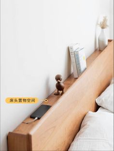 a bed with a wooden head board and white sheets on it, next to a book shelf