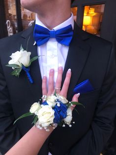 a close up of a person wearing a suit and tie with flowers in his lapel