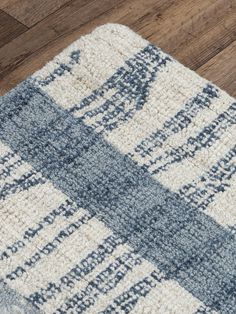 a blue and white rug on top of a wooden floor