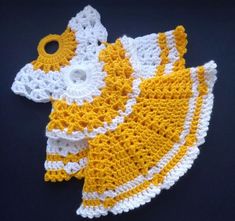 two yellow and white crocheted dishcloths on a black surface