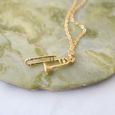 a gold necklace with the letter f on it