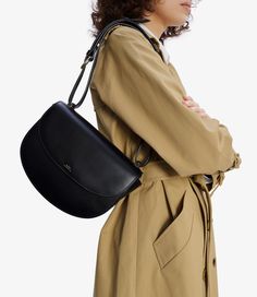 A.P.C. Women's bag. - Bag in the shape of an inverted Demi-Lune in smooth vegetable-tanned leather.- Magnetic flap closure.- Adjustable leather shoulder strap.- Can be worn on the shoulder or across the chest.- Brass rings around the handle.- One large compartment.- One small interior pocket.- Reinforced rounded bottom.- Embossed goldtone 'A.P.C. Rue Madame Paris' logo. Belly Bag, Paris Logo, White Shirt Men, Black Leather Bag, White Shirts Women, Leather Label, Black Leather Bags