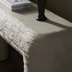 a table with a book and vase on it