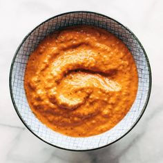 a bowl filled with sauce on top of a table