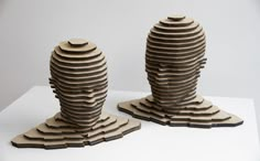 two tall wooden sculptures sitting on top of a white table