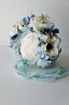 a crocheted ball of yarn with blue and white flowers on it next to a string