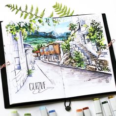 an open sketchbook with watercolors and markers