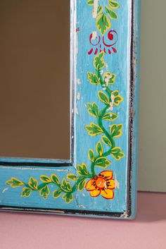 a painted mirror sitting on top of a pink table