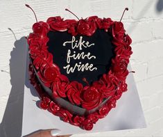 there is a heart shaped cake with writing on the top and roses in the middle