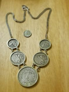 This necklace features vintage United States coins including one Morgan dollar coin, 2 walking Liberty half dollar coins and 2 standing Liberty quarters set into a sterling silver necklace. Vintage Sterling Silver Coin Necklace, Antique Round Coin Necklace Nickel Free, Antique Nickel-free Round Coin Necklace, Vintage Sterling Silver Coin Necklace In Silver, Antique Silver Coin Pendant Necklace, Silver Coin-shaped Stamped Necklace, Vintage Silver Coin Necklace, Silver Coin-shaped Stamped Necklaces, Vintage Silver Coin Necklace With Charm