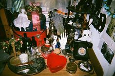 an assortment of items on a table in a cluttered room with christmas decorations and other things