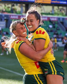 two female soccer players hugging each other on the field