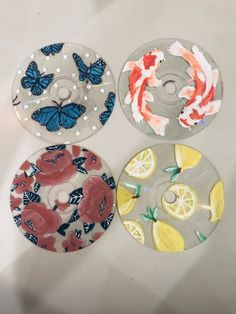 three plates with different designs on them and one has fish, lemons, and butterflies