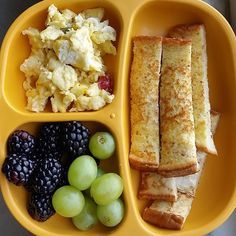 a yellow plate with fruit and toast on it