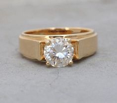 a gold ring with a white diamond in the center