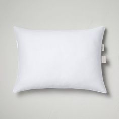 a white pillow with an adhesive tape on the front and back of it, against a gray background