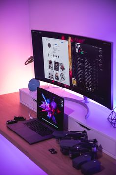 a laptop computer sitting on top of a wooden desk next to a monitor and mouse