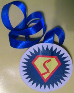 a blue ribbon is on top of a white and yellow badge with the letter s