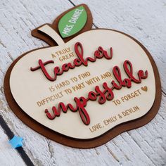 an apple shaped plaque with the words teacher impossible written on it