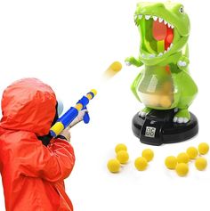 a child in a red raincoat is playing with yellow balls and a toy dinosaur